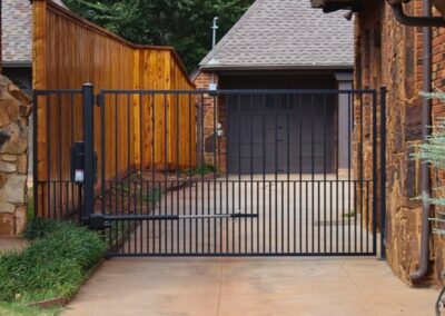 Residential automatic driveway gate with modern steel design showcased as an example of what Vector Fence can install for home security and convenience.