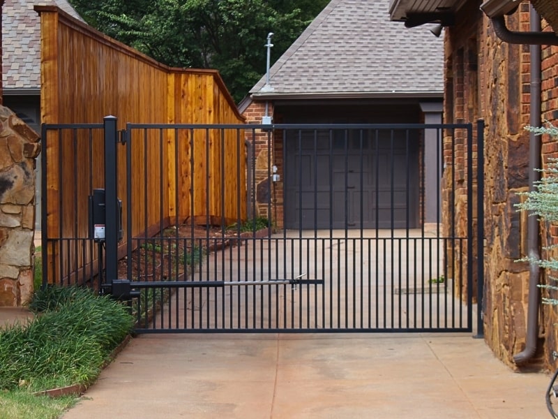 Residential automatic driveway gate with modern steel design showcased as an example of what Vector Fence can install for home security and convenience.