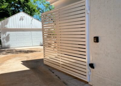 Modern white automatic driveway gate with keypad access installed at a Tulsa residential property.