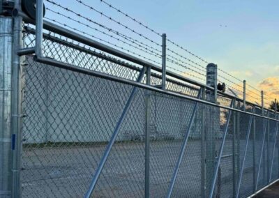 Commercial cantilever automated gate with barbed wire security top, showcasing a durable, high-security access solution for industrial properties.
