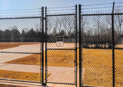 Commercial chain link fence and barbed wire gate installation showcasing the secure commercial fencing solutions provided by Vector Fence.