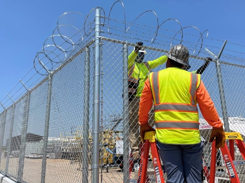 Commercial chain-link security fence installation with razor wire in Tulsa, completed by professional Vector Fence crews