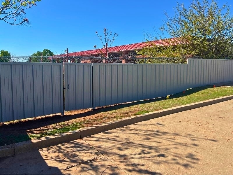 Commercial corrugated metal fence installation showcasing the durable and secure metal fencing solutions installed by Vector Fence