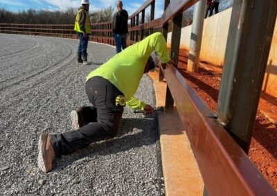 Vector Fence technician installing steel fencing at a baseball field, demonstrating precise craftsmanship and durable sports facility fencing solutions.