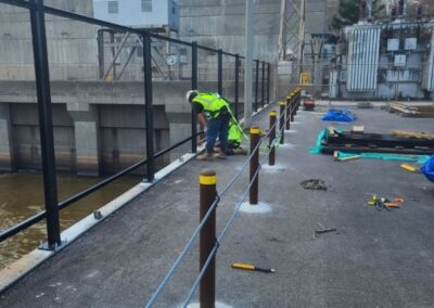 Vector Fence technician installing commercial security fencing at an industrial facility, demonstrating safety-focused installation and durable perimeter protection.