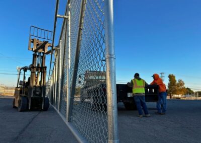 Vector Fence crew positioning a large cantilever chain link gate at a commercial site, showcasing heavy-duty installation and coordinated teamwork.