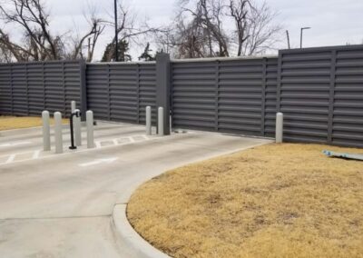 Commercial R-panel automatic gate installed with matching metal privacy fencing, showcasing a durable, modern access-control solution.