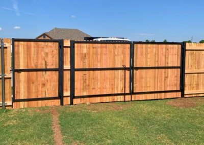 Residential cedar privacy fence with custom steel frame gates, showcasing a durable and reinforced gate installation built for long-term performance.