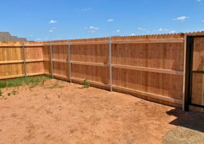 6-foot cedar residential fence with a steel frame gate showcasing Vector Fence’s wood fence installation services.