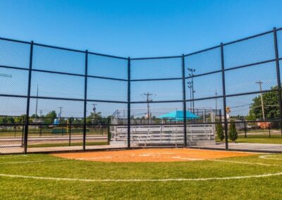 Commercial chain link backstop and sports field fencing installation showcasing the athletic fencing solutions provided by Vector Fence.