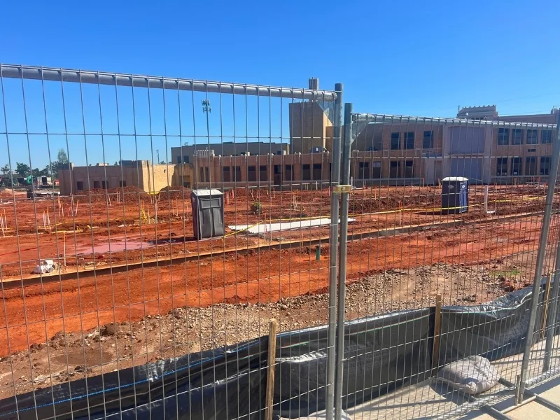 Temporary Construction Fence Installation | Vector Fence Temporary construction fence installed around an active building site, providing secure perimeter control and public safety during ongoing construction.