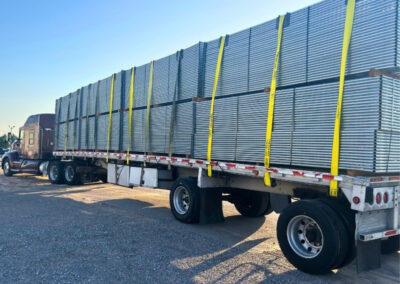 Truck loaded with stacked temporary fence panels, showing a large inventory ready for delivery to construction sites and events.