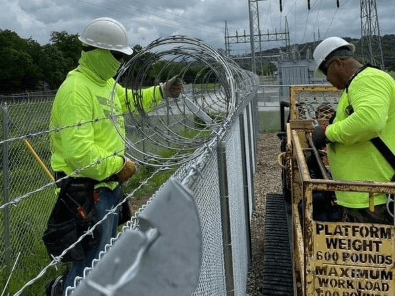 Commercial Chain Link Fence | VectorFence.com Commercial chain link fence installation with barbed wire security topping for a protected industrial property perimeter.
