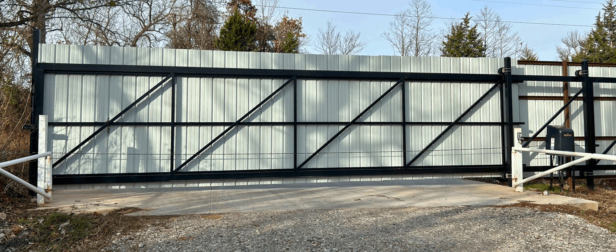 Corrugated Metal Automatic Slide Gate | VectorFence.com Corrugated metal automatic slide gate with black steel frame installed for secure vehicle access and property privacy.