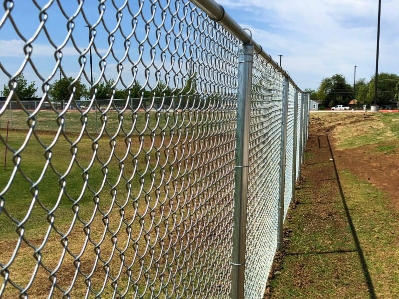 Galvanized Chain Link Fence Installation | VectorFence.com Galvanized chain link fence installed along an open property line for durable security and clear boundary protection.