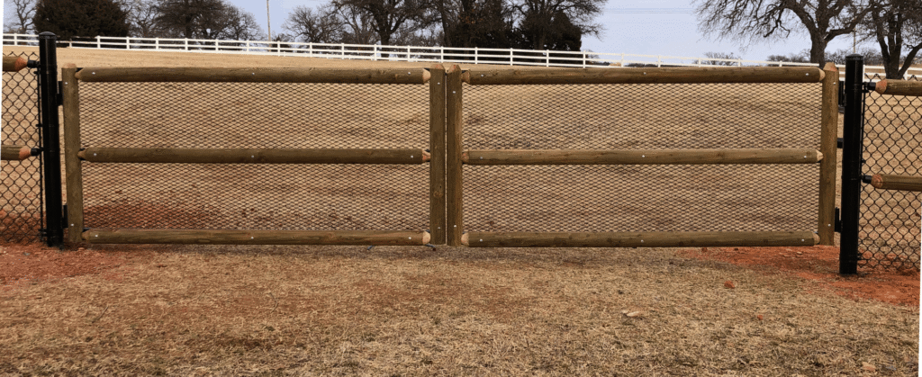 Custom Post and Rail Double Drive Gate with Chain Link | VectorFence.com Custom post and rail double drive gate with chain link backing installed for secure vehicle access and open property visibility.