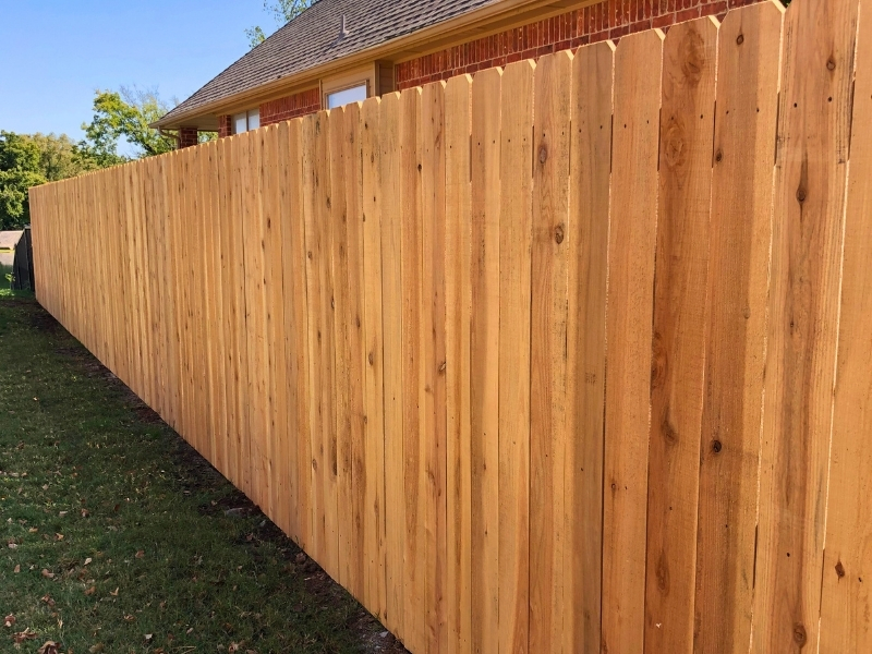 Tall cedar wood privacy fence installed along a residential side yard to create a private and secure outdoor space.