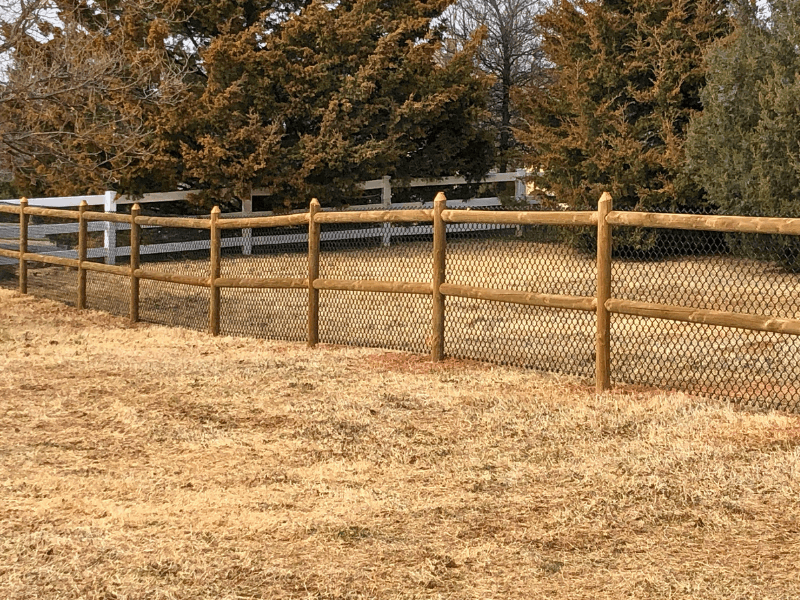 Round Rail with Chain Link Fence | VectorFence.com Round rail fence with chain link backing installed along an open property line for added containment and visibility.