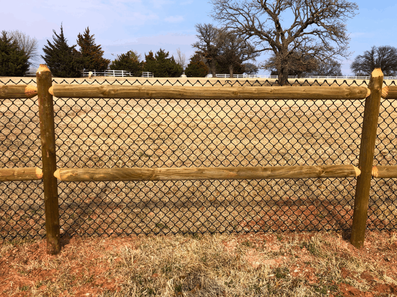 Round Rail Ranch Style Cedar Fence with Chain Link | VectorFence.com Round rail ranch style cedar fence with chain link installed by Vector Fence for open visibility and secure property containment.