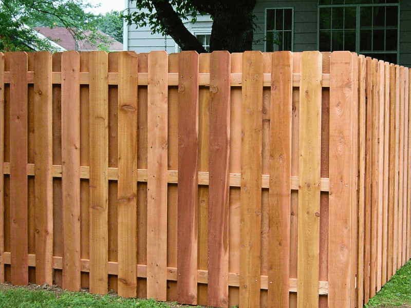 Shadowbox cedar fence with alternating wood pickets creating a semi-private backyard fence with airflow and natural style.